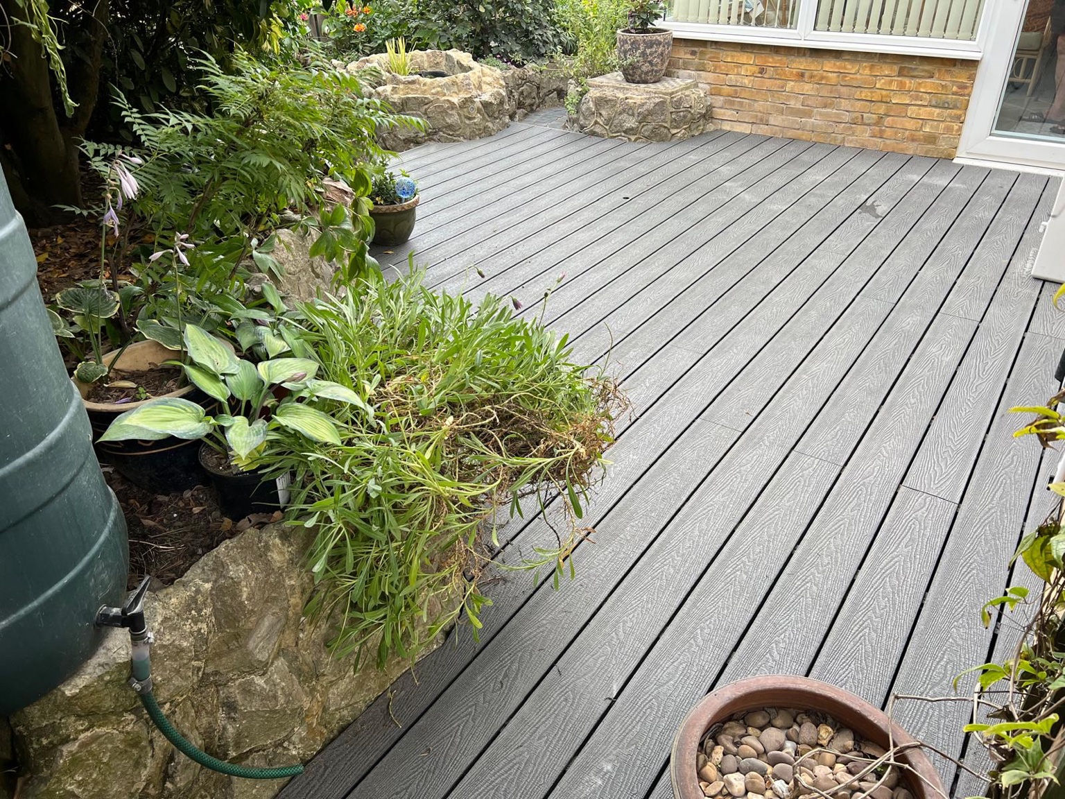 Composite decking shaped around ragstone borders in Ashford