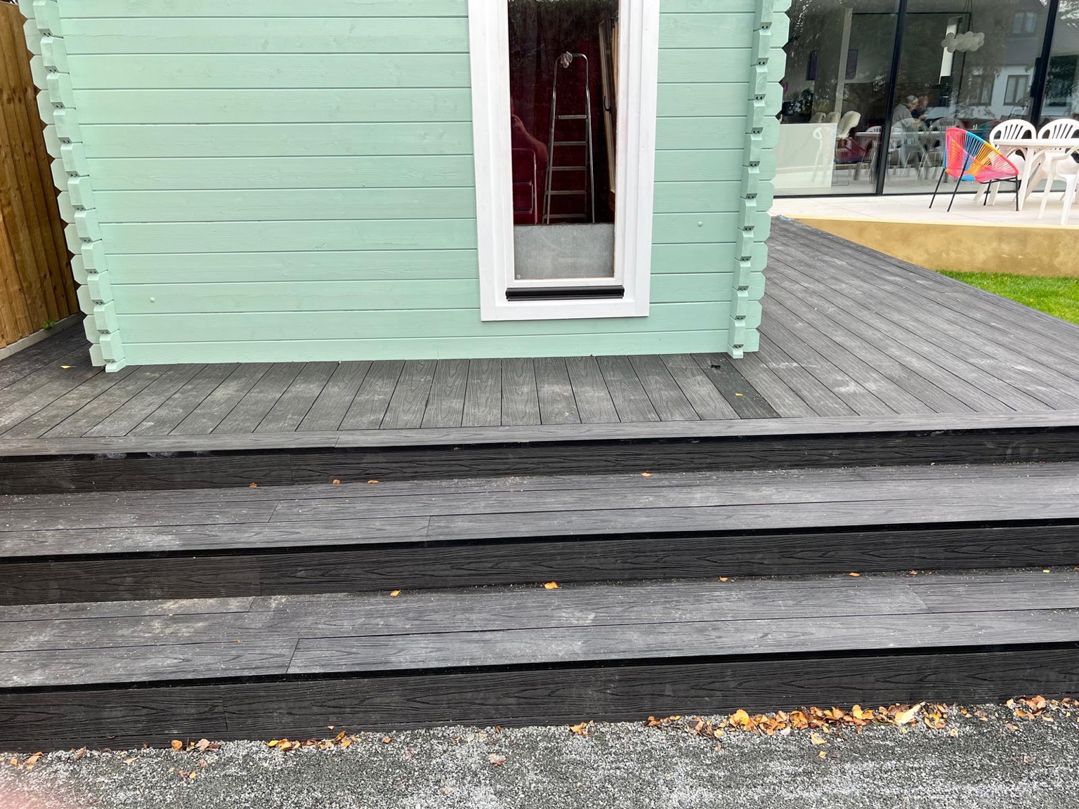 Charcoal composite decking around a Whitstable summerhouse