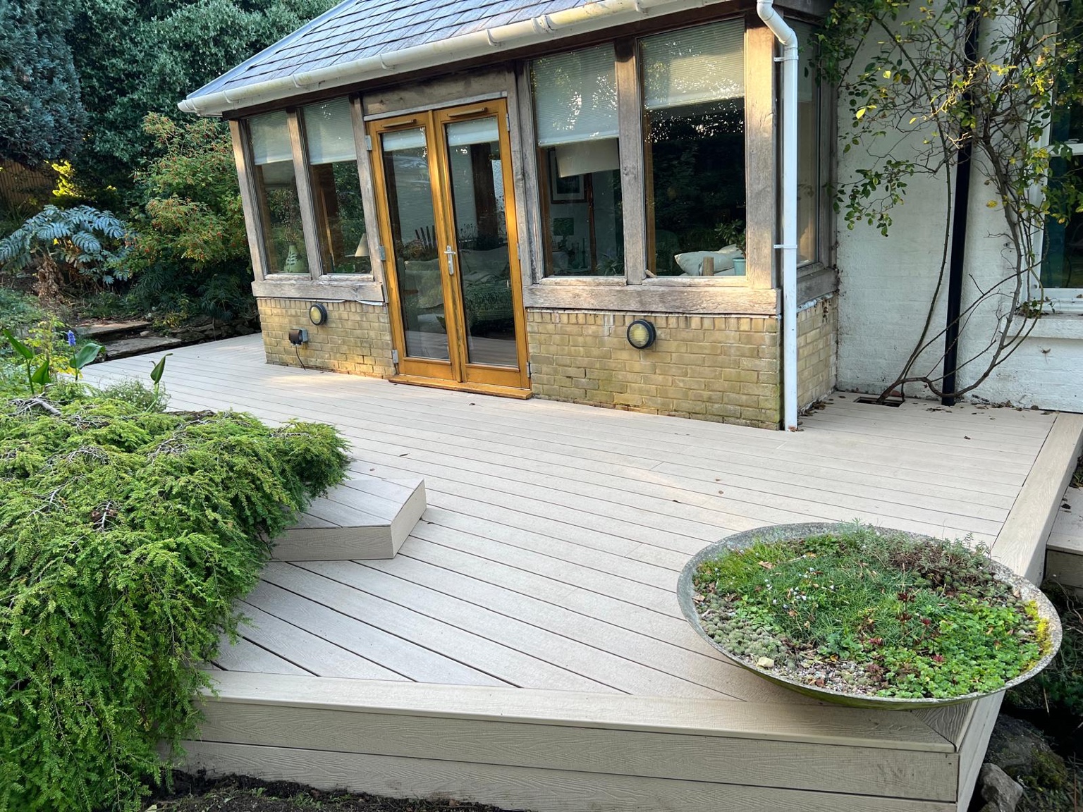 Light composite decking around a garden-facing room in Yorkletts, Whitstable